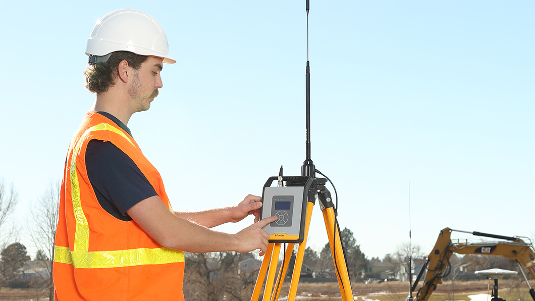 Construction worker using Trimble TDL450B radio with R750 GNSS modular receiver onsite